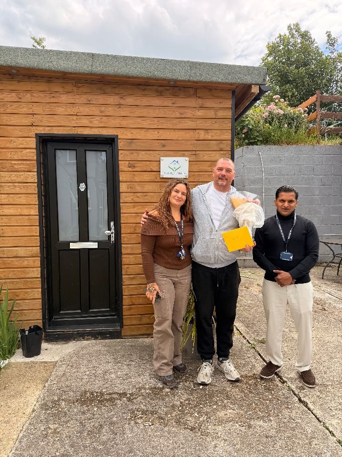 Steven celebrating a recovery milestone with two Tranquil Minds support workers outside his home.